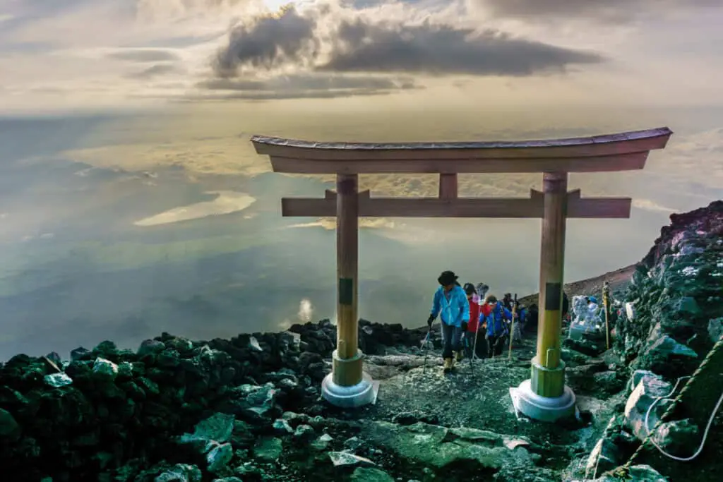 Hikers walking through a torii gate on Mt Fuji